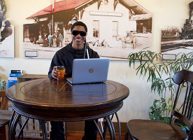 Picture of a blind young man working on a laptop.