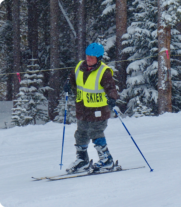 A blind skiier on the slopes during a snow storm.